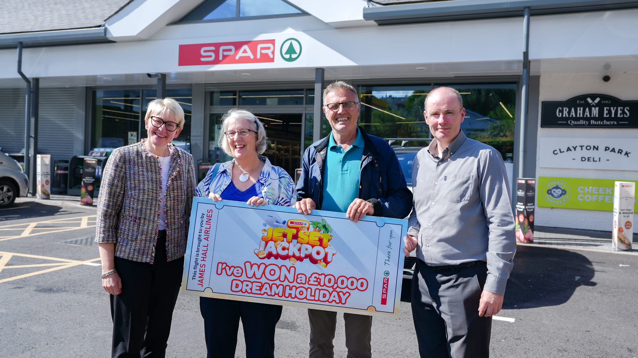 SPAR Jet Set Jackpot Winner Fiona Foy (centre left) winner of SPAR Jet Set Jackpot with her husband Michael (centre right) flanked by SPAR Company Stores Director Fiona Drummond (left) and Area Manager James Watt (right), both of James Hall & Co. Ltd outside SPAR Bowness.